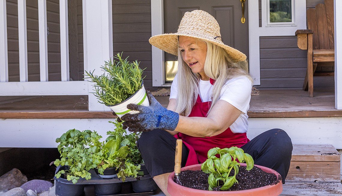 Caucasian woman planting seedling on front stoop